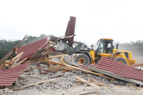 An excavator demolishing a family home in Zimbabwe